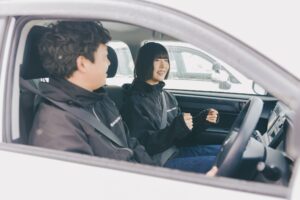教習車の車内で笑顔で話をする指導員と教習生