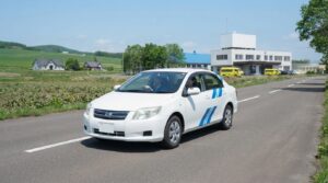 進路変更のウインカーを正しいタイミングで出して走る教習車